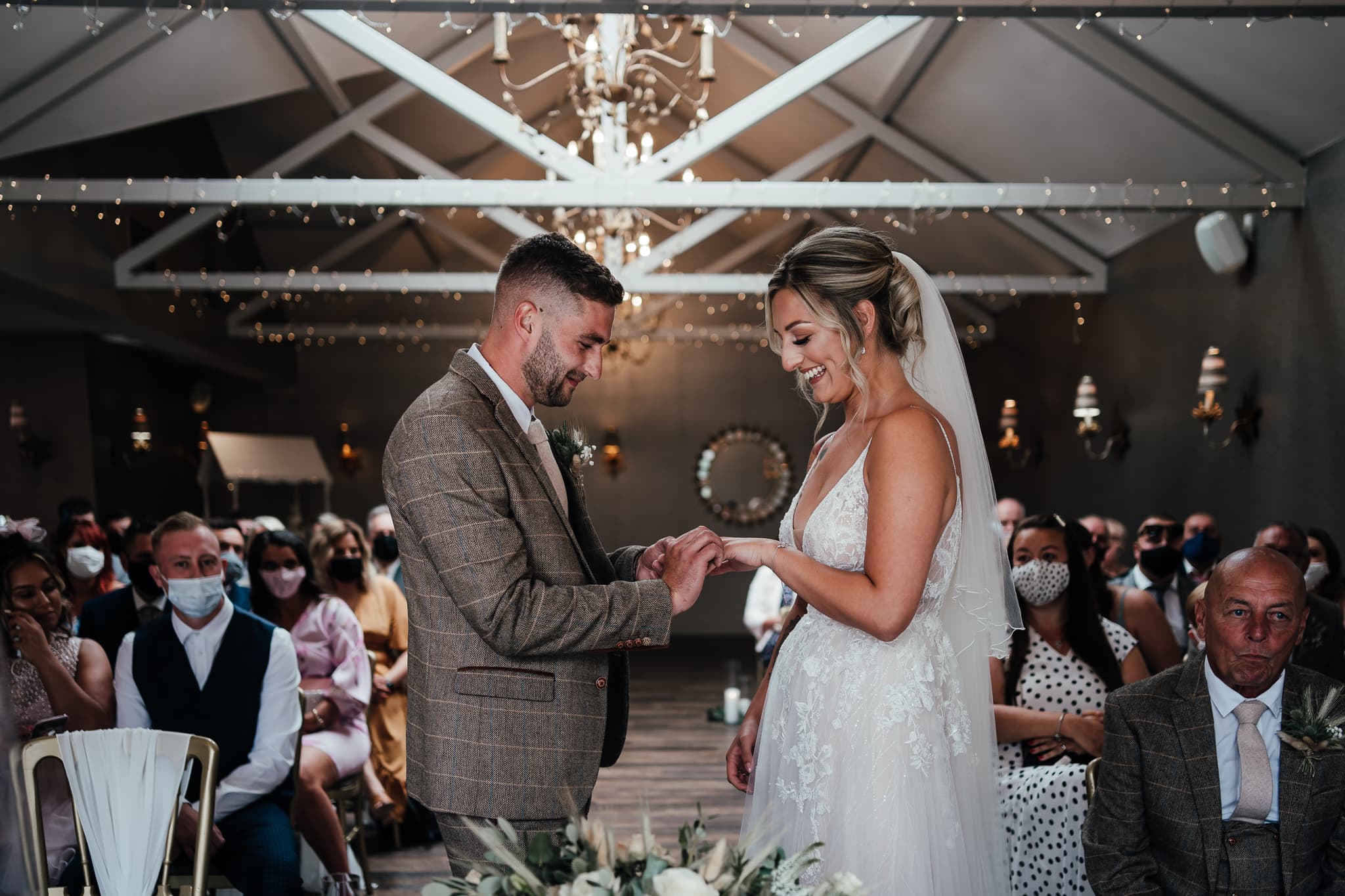 Wedding Photography at Cockliffe House - bride and groom exchange rings. their guests behind them