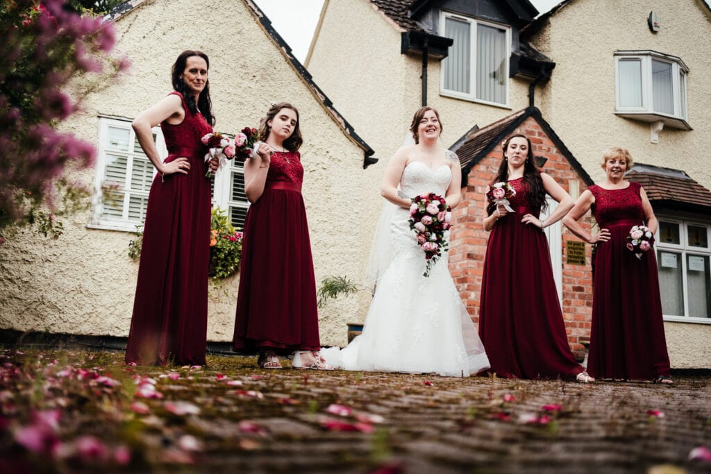 Bride and bridesmaids pose in front of The Cottage hotel in Ruddington