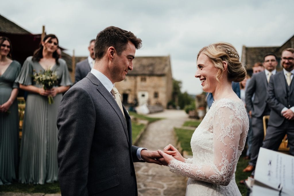 Wedding at Barlow Woodseats Hall - bride and groom exchange rings in outdoor ceremony