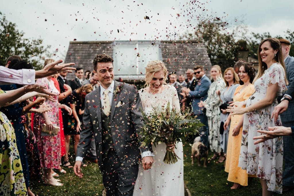 Wedding at Barlow Woodseats Hall - bride and groom walk down aisle getting covered in confetti